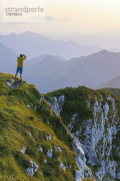 Fotograf fotografiert  Gipfel der Benediktenwand bei Sonnenuntergang  hinten Silhouetten von Bergen  Bayerische Voralpen  Bayern  Deutschland  Europa