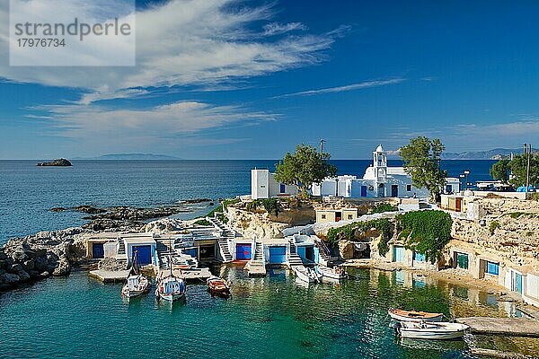 Typische griechische Insellandschaft  kleiner Hafen mit Fischerbooten in kristallklarem türkisfarbenem Wasser  traditionelle Kirche mit weißen Häusern  Dorf Mandrakia  Insel Milos  Griechenland  Europa