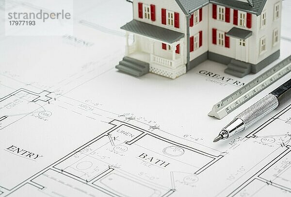 Modellhaus  Ingenieurbleistift und Lineal auf individuellen Hausplänen ruhend