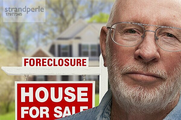 Depressiver älterer Mann vor einem Immobilienschild und einem Haus mit Zwangsvollstreckung