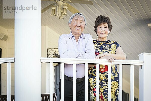 Attraktives glückliches chinesisches Paar  das sein Haus im Freien genießt