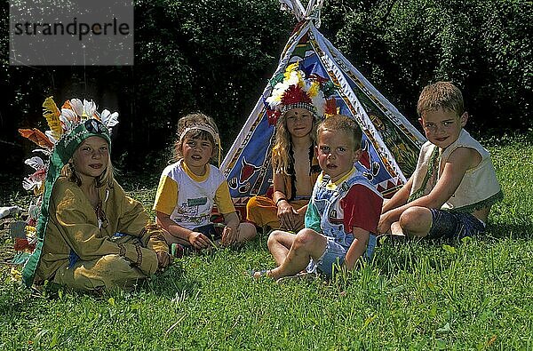 Kinder auf einer Wiese mit Zelt spielen Indianer