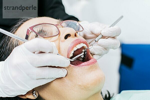 Zahnärztin bei der Untersuchung eines Patienten  Nahaufnahme eines Zahnarztes mit einem Patienten  Zahnarzt bei der Wurzelbehandlung eines Patienten  Zahnarzt bei der zahnärztlichen Untersuchung