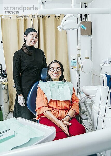 Zahnarzt mit Patient lächelnd in die Kamera im Büro  zufriedener Zahnarzt und Patient lächelnd in die Kamera  zufriedener Zahnarzt und Patient Konzept