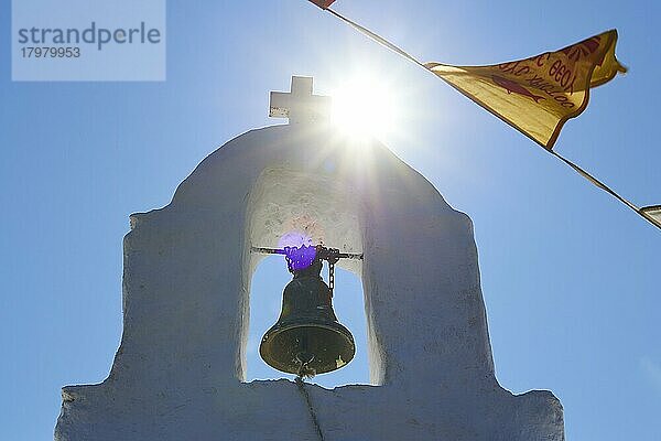 Weißer Glockenturm  Nahaufnahme  Himmel blau und wolkenlos  Pfingsten Gottesdienst  Kapelle Agias Triadas  Gegenlicht  Sonne als Stern  Orthodoxe Fahnen  nahe Korfi  Insel Andros  Kykladen  Griechenland  Europa