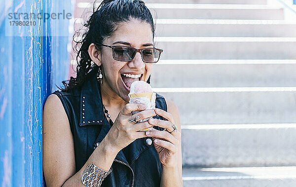 Urbanes Mädchen ißt eine Eiswaffel  Ein Mädchen ißt ein Eis im Freien  Mädchen genießt ein Eis  Nahaufnahme einer Frau mit einem Eis