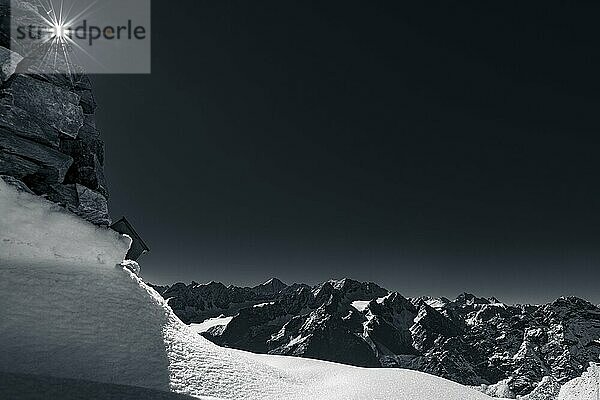 Bergpanorama mit Sonnenstern und Schneefläche im Vordergrund und Sellrainer Bergen  Sellrain  Innsbruck  Tirol  Österreich  Europa