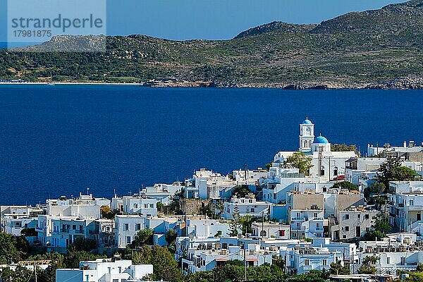 Blick auf das Dorf Plaka mit der traditionellen griechisch-orthodoxen Kirche  den weiß getünchten Häusern und der Meeresküste. Insel Milos  Griechenland  Europa