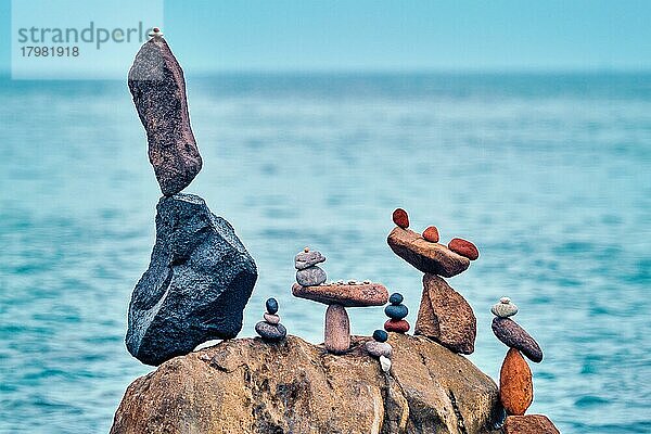 Konzept des Gleichgewichts und der Harmonie  Steine Kieselsteine stapelt auf Stein am Strand Küste des blauen Meeres in der Natur  Meditative Kunst der Steinstapelung