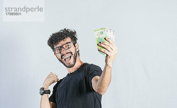 Aufgeregter Mann mit Geld in der Hand  glücklicher Mann  der Geldscheine in der Hand hält  Verdienst- und Sparkonzept