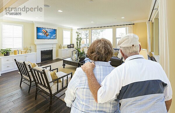 Liebevolles älteres Paar mit Blick auf ein schönes individuelles Wohnzimmer