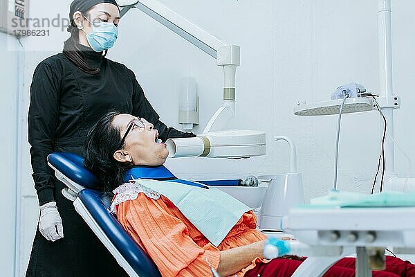 Eine Zahnärztin  die Röntgenaufnahmen macht  die Röntgenaufnahmen bei einem Patienten macht