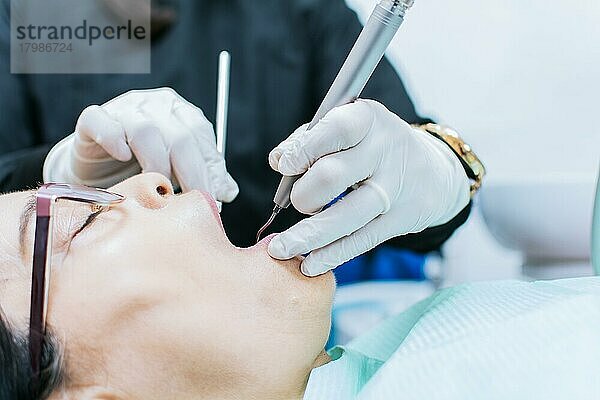 Nahaufnahme eines Patienten  der von einem Zahnarzt untersucht wird  Zahnarzt  der eine Wurzelbehandlung bei einem Patienten durchführt  der eine zahnärztliche Untersuchung durchführt