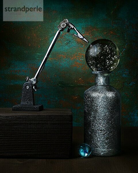 Thema Mystik  Aberglaube  Astrologie  Stillleben mit Glaskugel auf silberner Flasche neben Hilfswerkzeug Dritte Hand  Studioaufnahme  Symbolfoto
