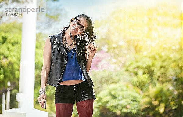 Latin girl listening to music outside  Urban girl enjoying music with headphones  happy woman listening to music outside  concept of girl listening to music