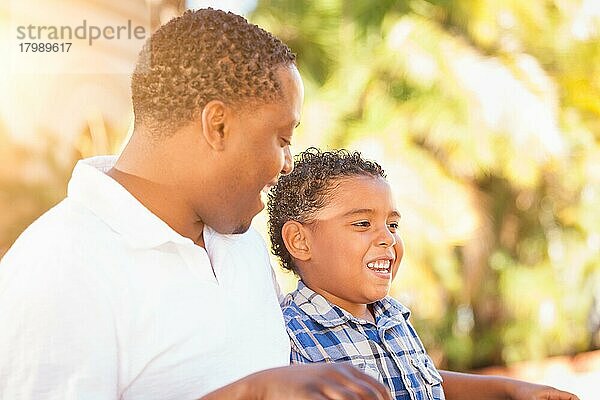 Gemischtrassiger sohn und afroamerikanischer vater spielen zusammen im freien