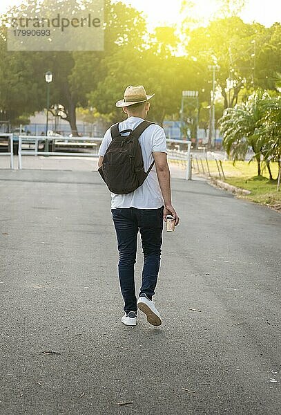 Mann gehend auf der Straße mit Rucksack  von hinten