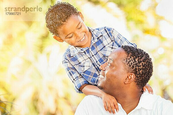 Gemischtrassiger sohn und afroamerikanischer vater spielen zusammen im freien