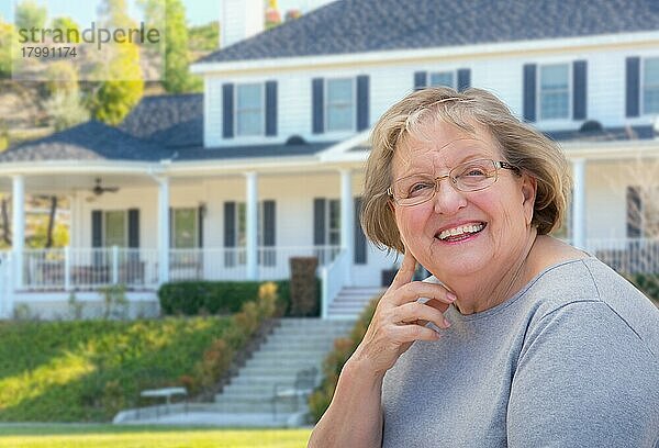 Ältere erwachsene Frau vor einem schönen Haus