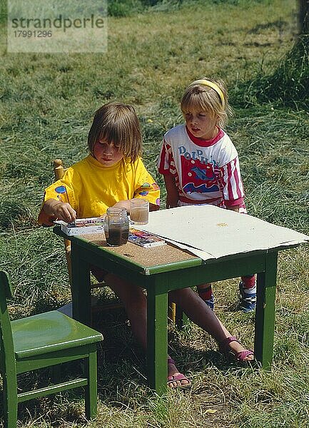 2 kleine Mädchen malen im Freien
