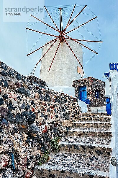 Alte traditionelle weißgetünchte griechische Windmühle auf der Insel Santorin in Oia mit Treppen auf der Straße  Oia Dorf  Santorin  Griechenland  Europa