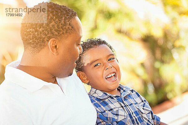 Gemischtrassiger sohn und afroamerikanischer vater spielen zusammen im freien