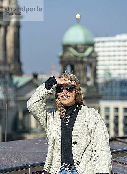 Junge Frau schützt ihre Augen in der Sonne vor dem Gegenlicht  Berlin  Deutschland  Europa