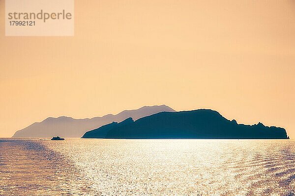 High speed catamaran vessel and Cyclades greek islands silhouettes in Aegean sea. Greece