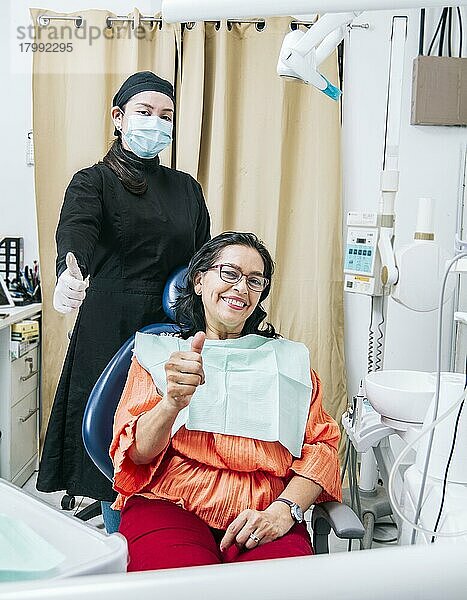 Zahnarzt mit Daumen nach oben Patient im Büro  Frau zeigt Daumen nach oben sitzen in Zahnarztpraxis  Zahnarzt und zufriedener Patient mit Daumen nach oben