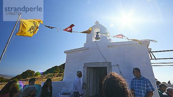 Superweitwinkel  Pfingsten Gottesdienst  Kapelle Agias Triadas  Menschen vor Kapelle  Gegenlicht  Sonne als Stern  Orthodoxe Fahnen  nahe Korfi  Insel Andros  Kykladen  Griechenland  Europa