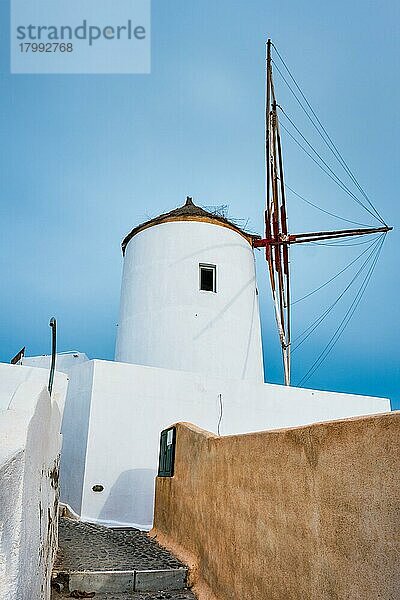 Alte traditionelle weißgetünchte griechische Windmühle auf der Insel Santorin in Oia mit Treppen auf der Straße  Oia Dorf  Santorin  Griechenland  Europa