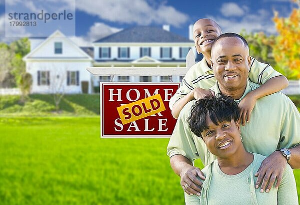 Glückliche afroamerikanische Familie vor einem zum Verkauf stehenden Immobilienschild und Haus