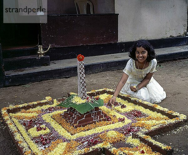 Ein Mädchen beim Blumenschmuck oder Pookalam während des Onam-Festes in Kodungallur  Kerala  Indien  Asien