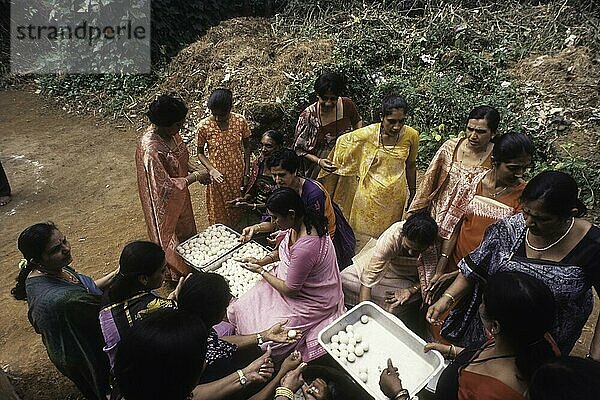 Kodava-Frauen bei der Herstellung des Reisballs Kadamputtu  während des Huthri-Festes  Kodagu  Karnataka  Indien  Asien