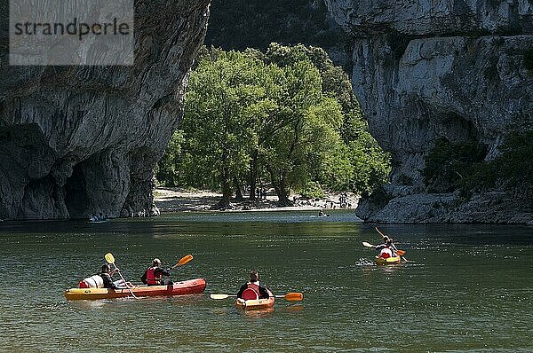 Menschen  die mit dem Kanu auf dem Fluss in Richtung Kalksteinbogen fahren  Pont d'Arc  Fluss Ardeche  Ardèche-Schlucht  Ardeche  Rhône-Alpes  Frankreich  Mai  Europa