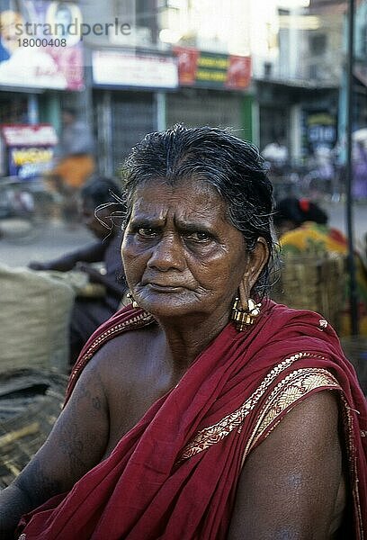 Eine alte Frau aus dem Dorf sitzt auf der Straße von Madurai und trägt massive Ohrringe  um ihre Ohrlöcher zu verlängern  Tamil Nadu  Indien  Asien