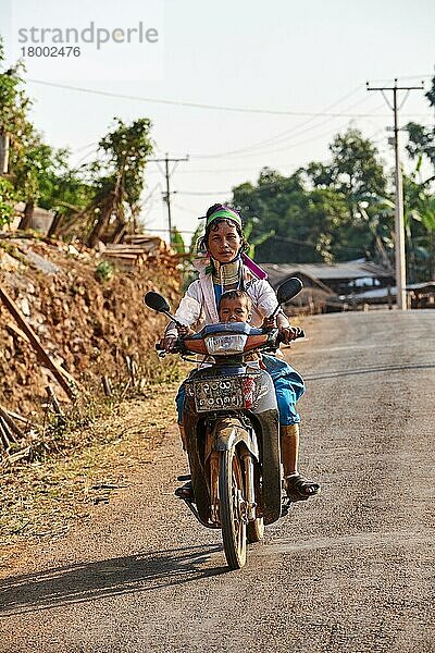 Frau aus Kayan Lahwi mit Messinghalswicklung und traditioneller Kleidung  die mit ihrem Kind Motorrad fährt  Pan Pet Region  Kayah State  Myanmar  Asien