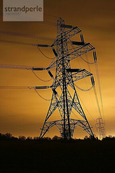 Strommast und Freileitungen  nachts beleuchtet von der Lichtverschmutzung der Stadt Leicester  Leicestershire  England  Großbritannien  Europa