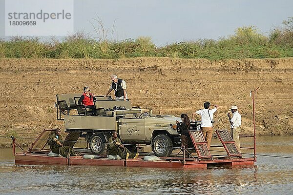 Safari-Fahrzeug und Touristen  die den Fluss auf einem Ponton überqueren  River Luangwa  South Luangwa N.P.  Sambia  Juni  Afrika