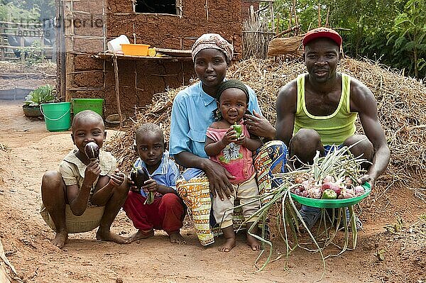 Familie zeigt im Garten angebautes Gemüse  Ruanda  Afrika