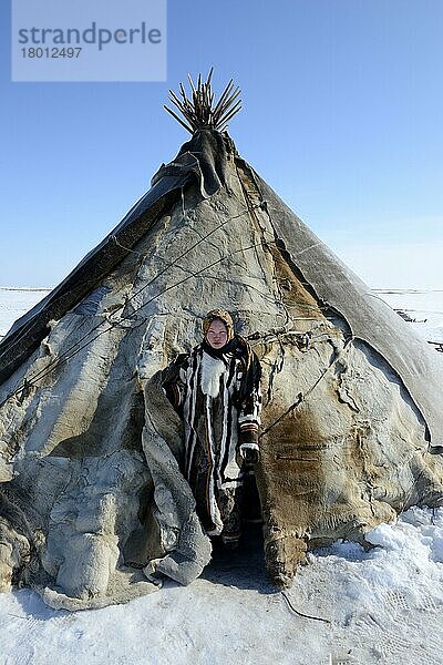 Carolina Serotetto  ein Teenager-Mädchen der Nenets am Eingang ihres mit Rentierfellen überzogenen Zeltes und warm gekleidet in ihrem traditionellen Rentierfellmantel  Distrikt Yar-Sale  Jamal  Nordwest-Sibirien  Russland  Europa