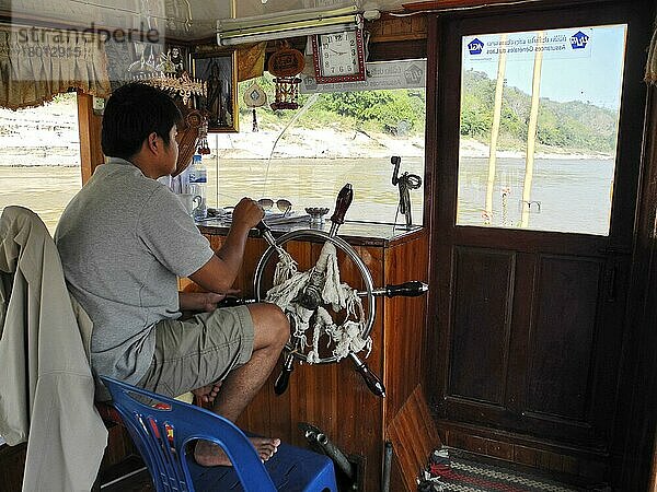 Kapitän am Ruderstand  Boot auf Fluss Mekong  Huay Xai  Pak Beng  Mekong  Laos  Asien