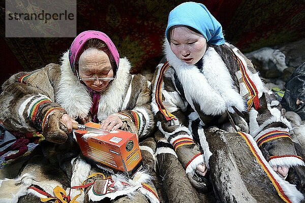 Zwei Generationen von Nenet-Frauen  eine ältere Frau und ein Mädchen  nähen und tragen den traditionellen Mantel aus Rentierfell  Distrikt Yar-Sale  Jamal  Nordwest-Sibirien  Russland  Europa