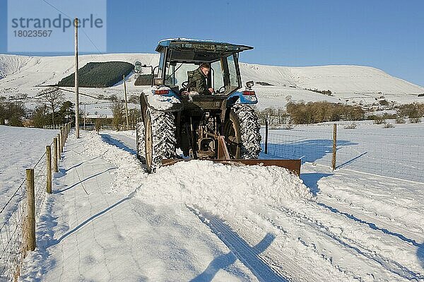 New-Holland-Traktor räumt Schnee von landwirtschaftlicher Spur  mit Heckschneepflug  Whitewell  Lancashire  England  Winter