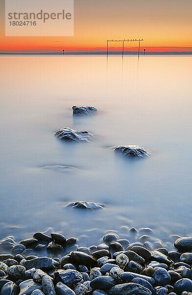 Blick von Arbon über den Bodensee bei Sonnenaufgang mit Steinen im Vordergrund