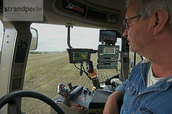 Fall 225 Traktorinnenraum und Landwirt  mit GPS und Samson-Vakuum-Güllewagen-Steuerpult  Injektion von Gülle in Stoppelfeld  Schweden  Mai  Europa