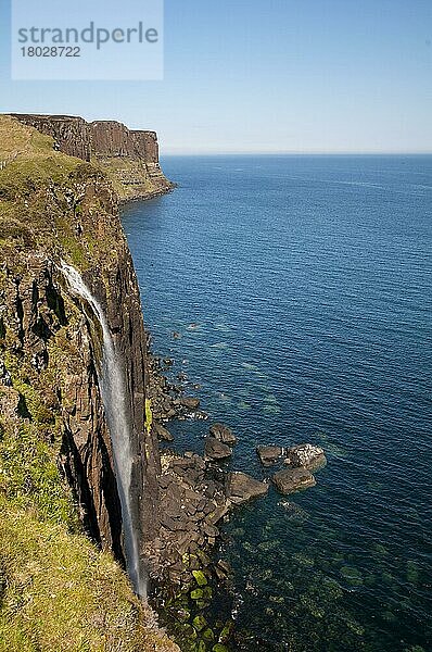 Blick auf die Küstenlinie mit einem Wasserfall  der über Klippen ins Meer stürzt  mit Kilt Rock im Hintergrund  Mealt Falls  in der Nähe von Sound of Raasay  Trotternish Peninsula  Isle of Skye  Innere Hebriden  Schottland  Mai
