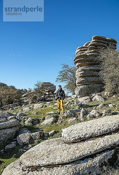 Junger Mann steht auf Felsen  Felsformationen aus Kalkstein  Naturschutzgebiet El Torcal  Torcal de Antequera  Provinz Malaga  Andalusien  Spanien  Europa