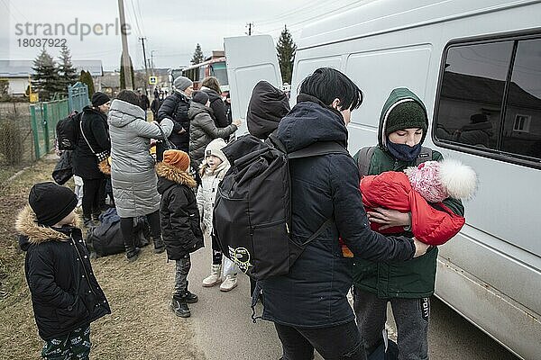 Ukrainische Flüchtlinge  auf dem Weg zur Grenze hat sich eine lange Autoschlange von fast 20 Kilometern gebildet  die Flüchtlinge sind meist zu Fuß unterwegs  Kleinbusse bringen Frauen und Kinder über einem Streckenabschnitt an die Grenze  Mostyska  Ukraine  Europa