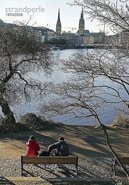 Menschen auf einer Parkbank an der Binnenalster mit Blick auf die Stadtsilhouette  Hamburg  Deutschland  Europa